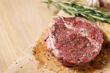 raw rib eye steak on board closeup, shallow focus
