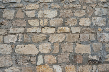 Gray decorative uneven cracked stone wall surface with cement
