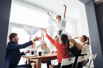 picture of happy business team celebrating victory in office. woman stand on table