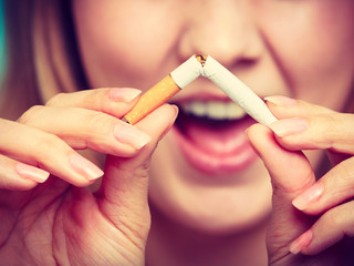 Smilling girl is breaking cigarette