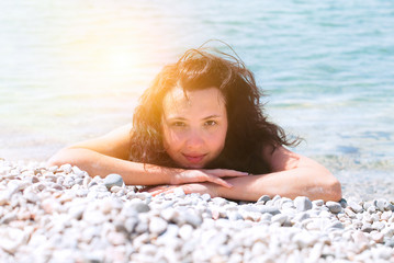 Beautiful Happy Girl is sunbathing on the Sunny Summer Beach