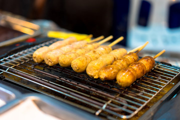 Thai sausage being roasted on a hot electric oven