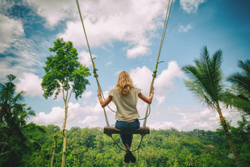 Young girl swinging in nature.