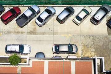 Many cars parked in outdoor parking.