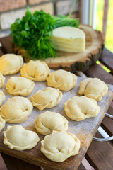 Dumplings raw on a wooden board. Russian and Ukraine national food. The process of cooking dumplings.