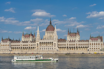 Fototapeta premium Parlamentsgebäude in Budapest zwischen blauem Himmel und blauer Donau mit Flussdampfer i