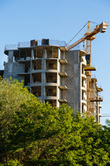 Construction of new house or building. General view. Unfinished cement building in the summer. The introduction of urbanization into nature. Capital construction in Ukraine