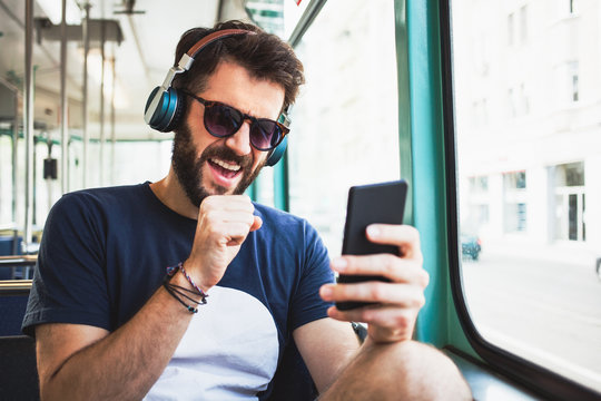 Young man listening to the music in public transport