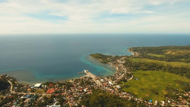 The town near the sea, houses, buildings, port. Aerial view coastal city nn the island of Bohol near the sea. Seascape with a town and the sea. 4K video. Travel concept. Aerial footage.