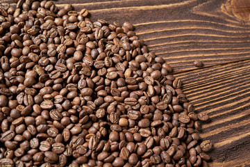 Roasted brown coffee beans on rough wooden table with blank copy space for text, top view background