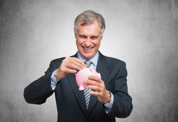 Man putting a coin in a piggy bank