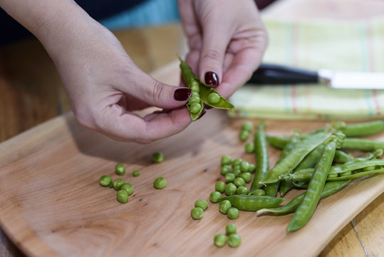 Hands women peel fresh picked green peas