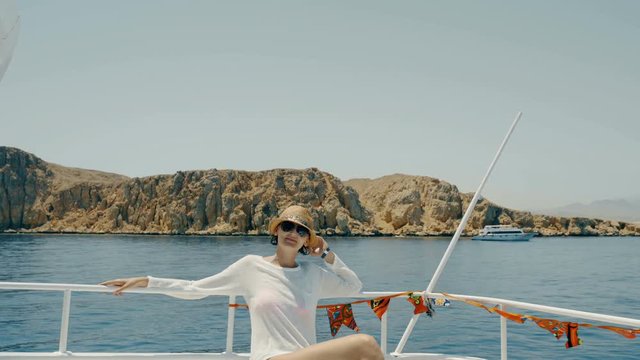 Woman enjoying a trip on yacht sitting on deck