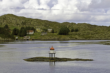 Fototapeta na wymiar Houses and tiny navigation lighthouse on fjord near Bergen, Norway