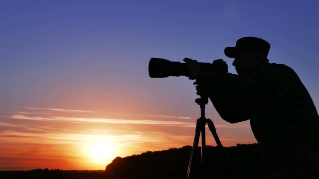 
4K.landscape man photographer works with camera in sunset time 
