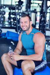 young man in fitness sport club exercise with weights and relaxing