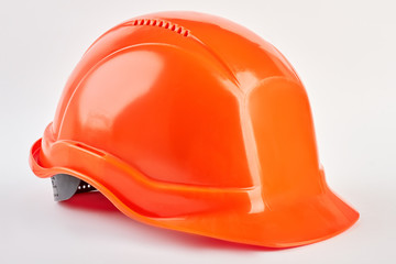 Plastic safety helmet isolated. Orange protective hat, white background. Industrial protection.