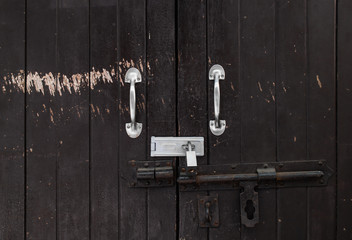 Background of vintage wood locked door with peeling paint and rusty hinge, safety concept