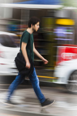 A student is walking speedy on the street during a spring day in Izmir (Turkey). Colors and shapes melt alltogether and he is like flying with his steps