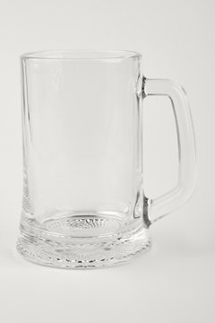 Empty beer glass isolated. Clear beer container, white background.
