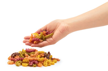 Female hand holds raw colored macaroni. Isolated on white background