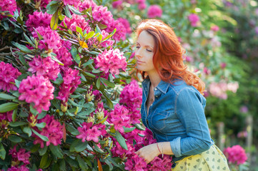Naklejka premium Young woman at a garden full of flowers