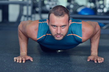 Fototapeta premium Man at the gym. Man makes exercises with barbell