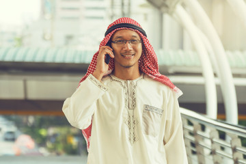 Arab businessman messaging on a mobile phone in the city