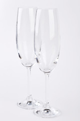 Closeup two clear champagne glasses. Wineglasses on white, front view.