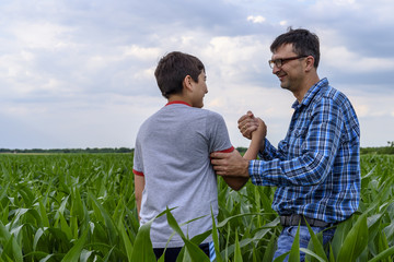 Son and father in a cornfield