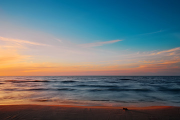 Beautiful twilight at Baltic sea beach. Waves blurred by long exposure. Gdansk Bay, Pomerania, Poland.