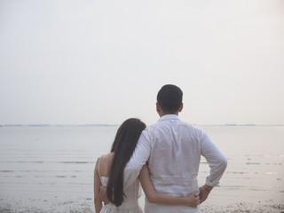 Young Asian couple in love on the beach.