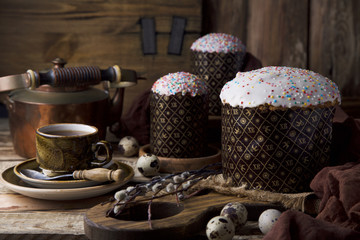 Easter cake with quail eggs and cup of coffee with brown tea pot on brown wooden background with space for text. Easter holidays. Still life