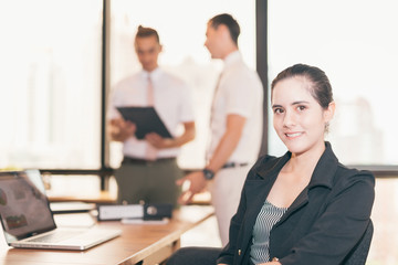 Face of beautiful business woman with her staff, people group in background at modern bright office indoors city view focus on women