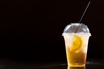 iced tea with lemon in takeaway plastic cup
