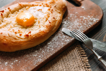 Khachapuri in Adzharian with Adyghe cheese, cheese and yolk. Traditional Caucasian food