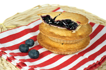 blueberry mini pies stacked on red and white striped cloth napkin