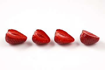 Two red fresh washed strawberries isolated on white background. Close up macro photo. Cut in half.