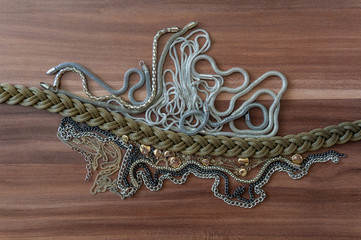 Mix of different size, color and texture chains on wooden background