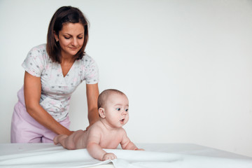 Woman doctor doing baby massage on white background