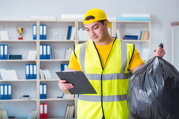 Man cleaning the office and holding garbage bag