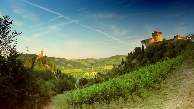 timelapse of castle and clock tower overlooking green valley in Emilia Romagna, Italy