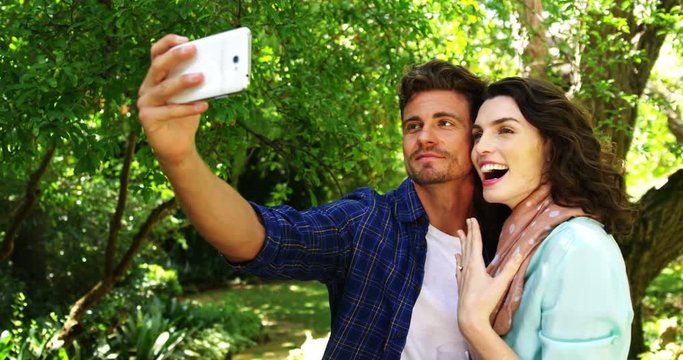 Romantic couple taking selfie from mobile phone in park