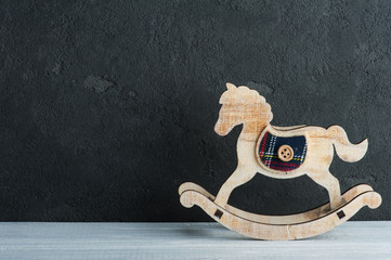 Vintage rocking horse next to black board