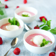 Cold creamy strawberry soup with a scoop of ice cream and mint