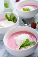 Cold creamy strawberry soup with a scoop of ice cream and mint