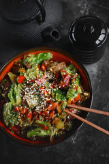 Noodles with vegetables and meat on a dark background, Asian food, Selective focus