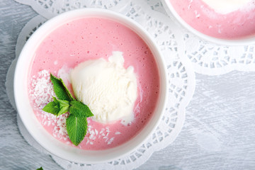 Cold creamy strawberry soup with a scoop of ice cream and mint