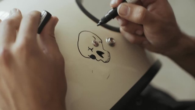 Calligraphy diy artists personalises his helmet as a private order comission, draws an anime skull in artisan way with acrylic ink marker