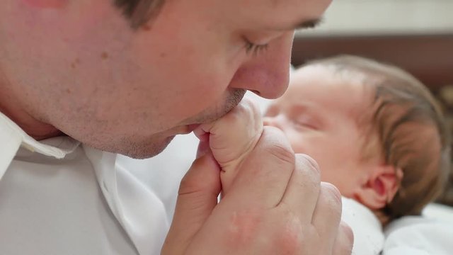 Pope kisses hand of baby, baby is sleeping on dad hands, children room